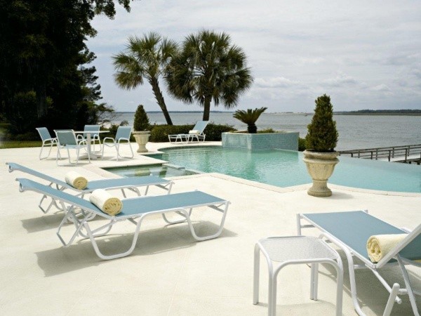 luxury patio including cyan colored deck chairs and an outdoor dining table with 4 chairs